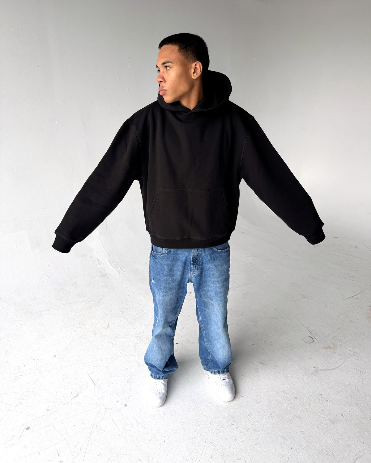 Brooklyn Classic pullover hoodie in Black, full length with arms out, on a model