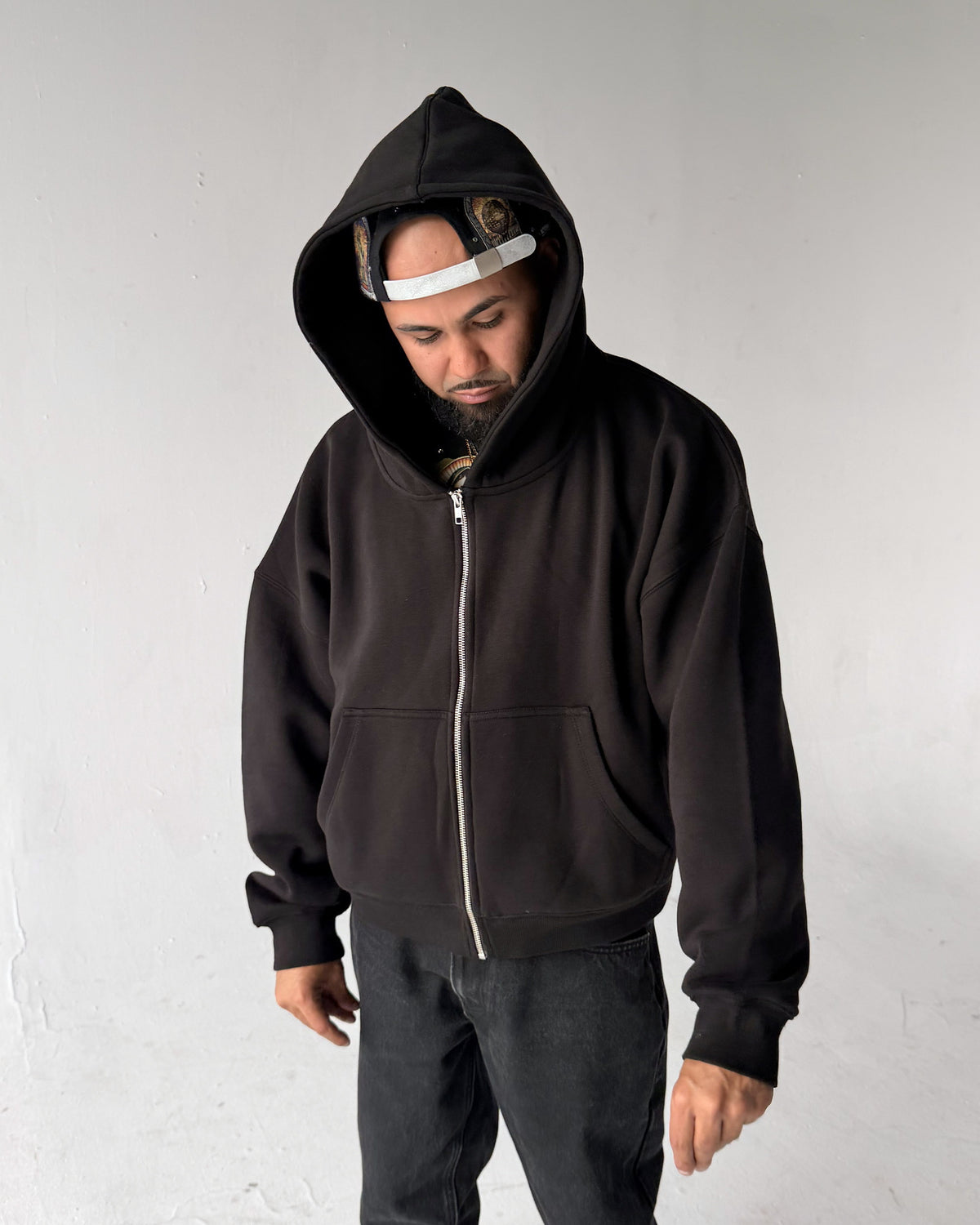 Oversized Crop Zip hoodie in Black, front with the hood up, on a model